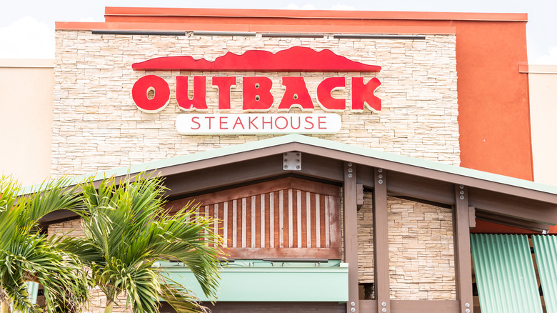 Exterior of an Outback Steakhouse with palm trees