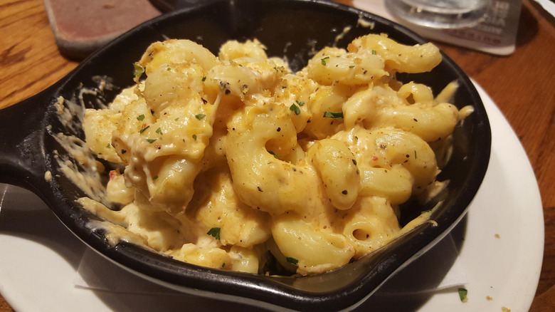 Outback's mac & cheese in a cast iron skillet, topped with bread crumbs and bacon bits