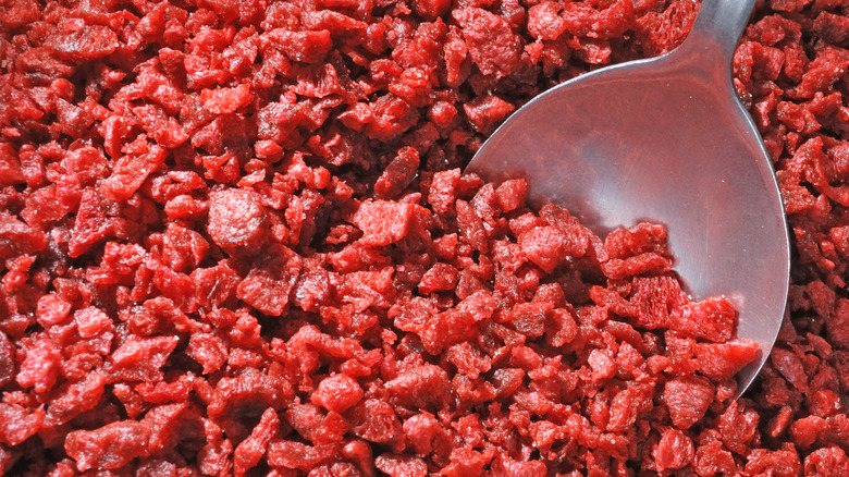 Spoon dipped in large amount of bacon bits