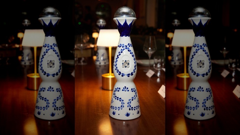 A bottle of Clase Azul tequila with a lamp in the background, mirrored
