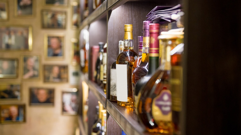 Various liquors on a shelf at a bar