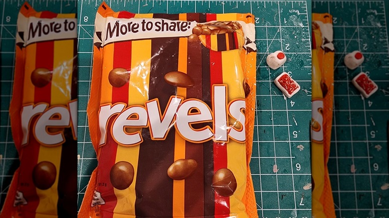 A packet of Revels on a measuring board with other candy next to the bag