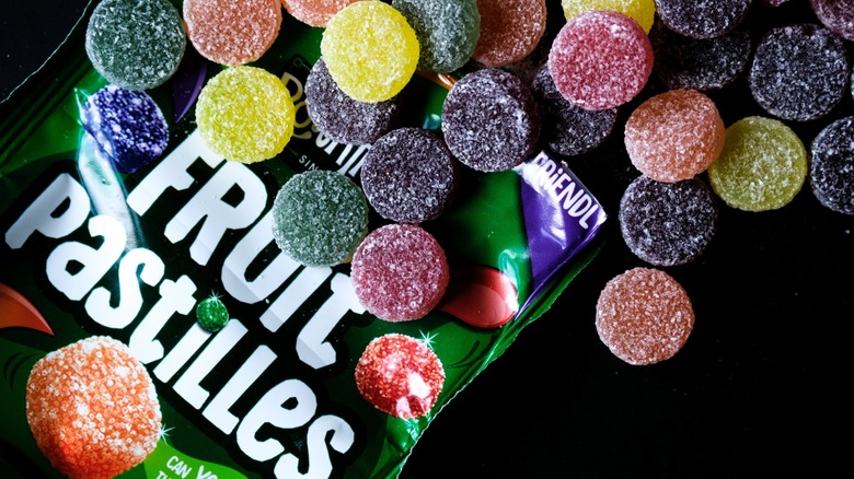 A bag of Fruit Pastilles with a selection of colorful sweets on top