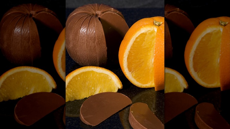 An unwrapped Terry's Chocolate Orange next to a regular orange