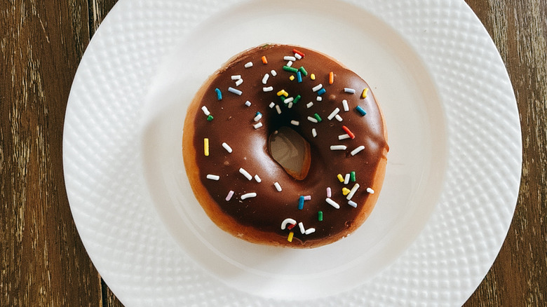 Krispy Kreme Chocolate Iced with Sprinkles Doughnut on white plate