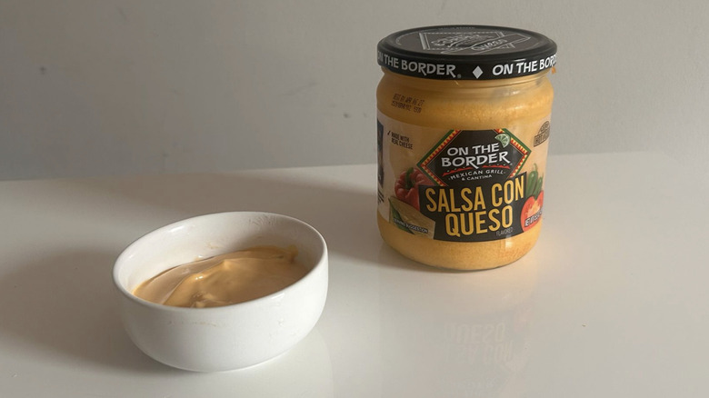 A jar of On the border queso spooned into a little white bowl