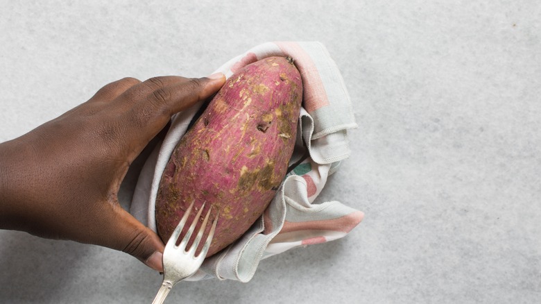 Man poking holes in a potato