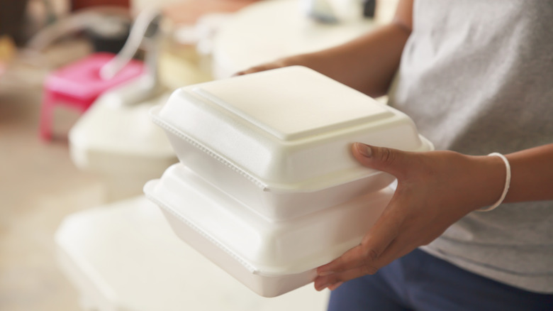 Woman holding Styrofoam containers
