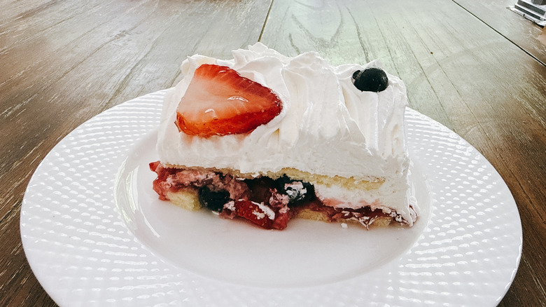 Publix chantilly cake slice on white plate on wooden table