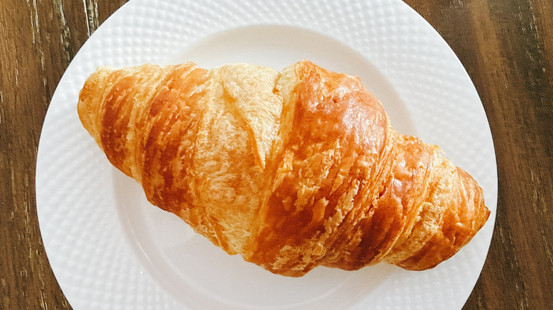 Publix croissant on white plate on wooden table