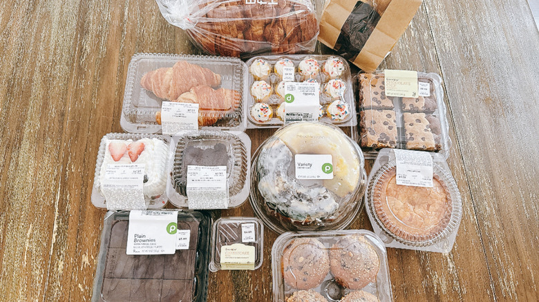 Variety of Publix bakery items on a wooden table in plastic packaging, including croissants, apple pie, and brookies