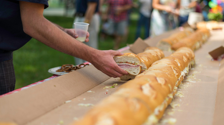 a man's takes a portion of a large party hero