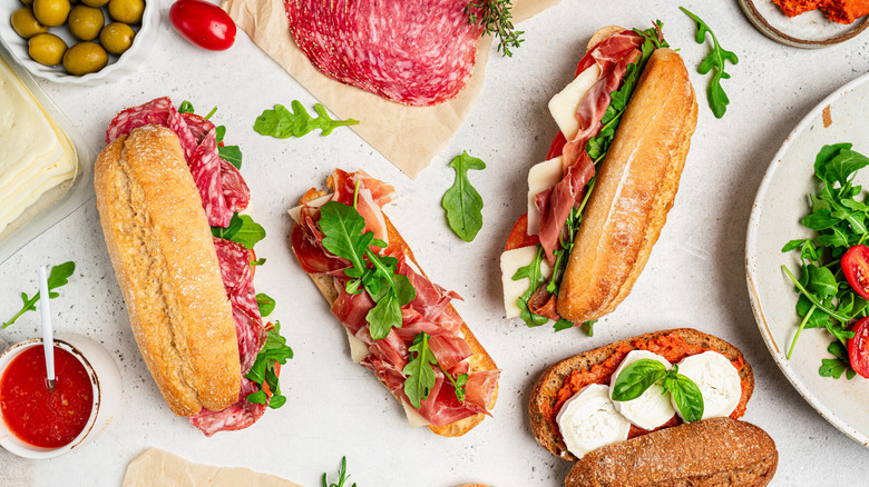 a variety of Italian-style sub sandwiches on a white surface