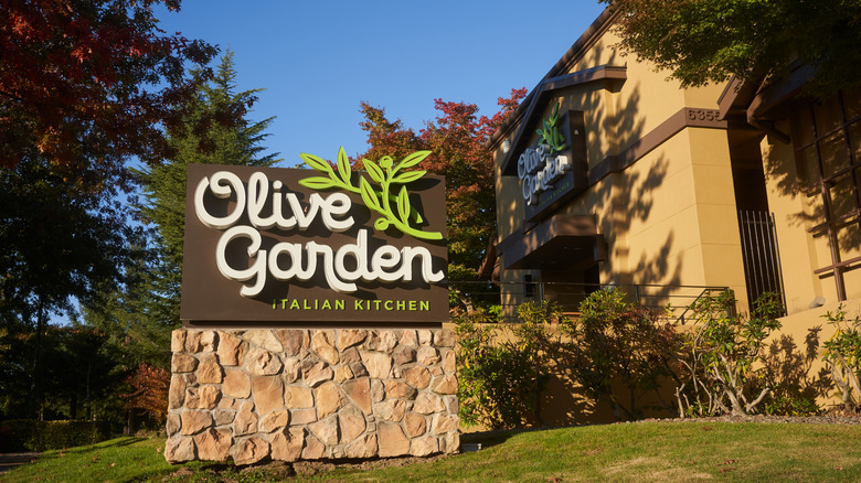 Sign in the front of an Olive Garden restaurant, day