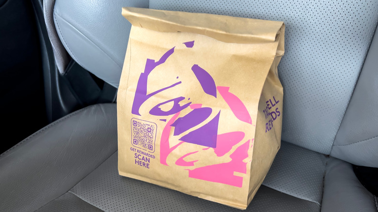 A Taco Bell takeout bag on a car seat