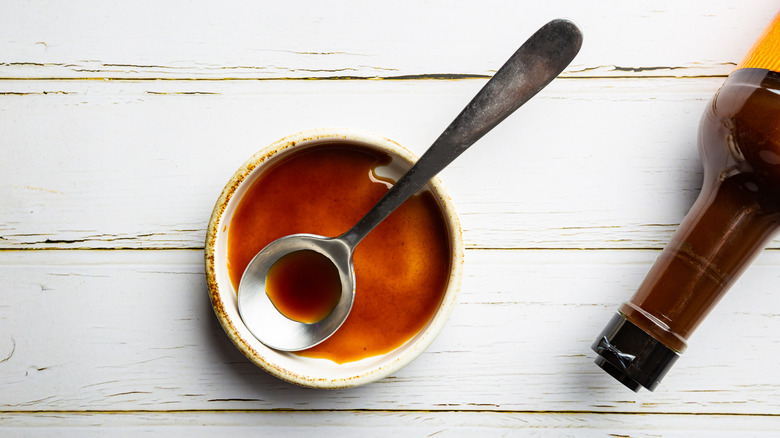 A bottle of Lea & Perrins Worcestershire sauce in a bowl with a spoon