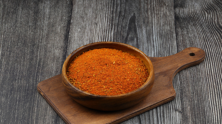 Cajun seasoning in a wooden bowl on a cutting board