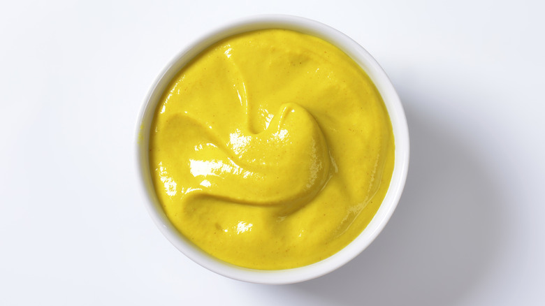 A white bowl of smooth mustard