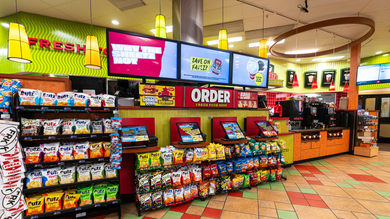 The order station and pick up station of a Sheetz gas station counter surrounded by snacks.