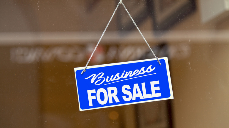 Photo of a sign in a window that reads "Business for Sale"
