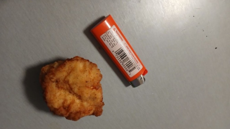 A lighter next to a piece of KFC chicken
