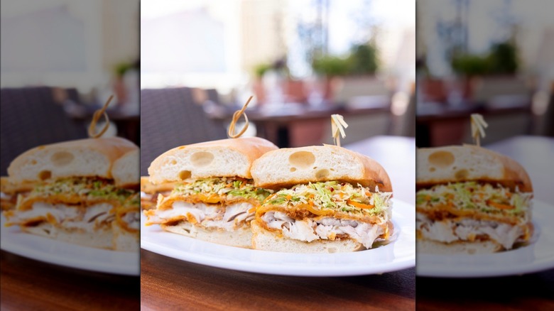 Fish sandwich at Ocean Prime Las Vegas, cut in half on white plate.