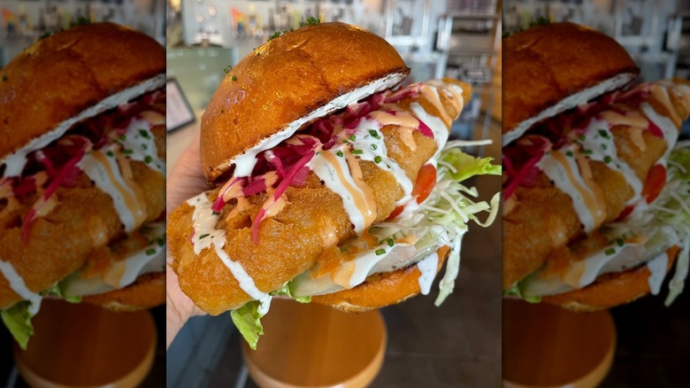 Hand holding Slapfish Reel Fish Sandwich.