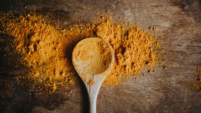 Ground turmeric on a wooden spoon