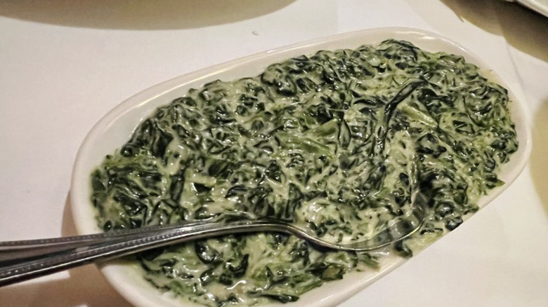 The Capital Grille's creamed spinach in white dish with silver spoon