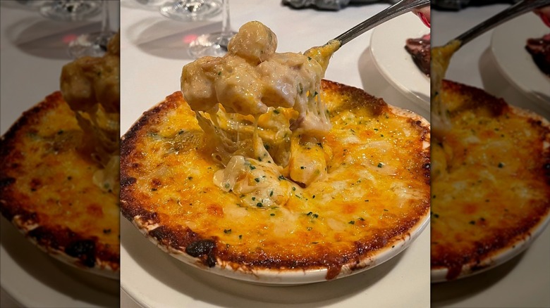 Morton's smoked gouda and bacon au gratin potatoes in white serving dish with spoon