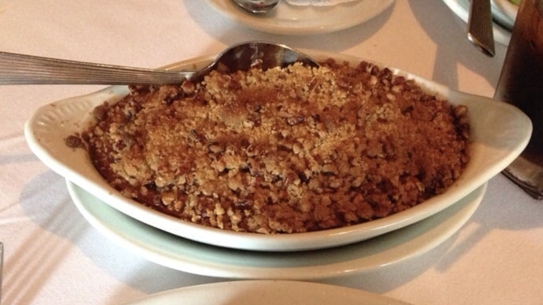 Ruth's Chris sweet potato casserole  in white serving dish with silver spoon