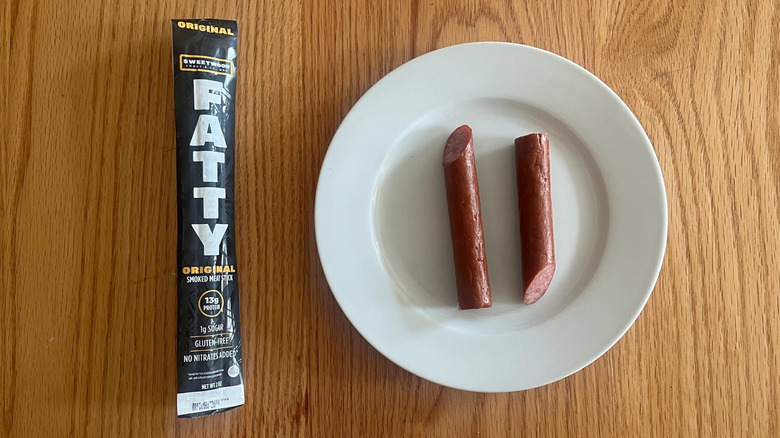 A Sweetwood Fatty meat stick cut in half on a plate