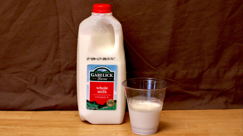 A jug of Garelick Farms brand whole milk beside a cup of milk