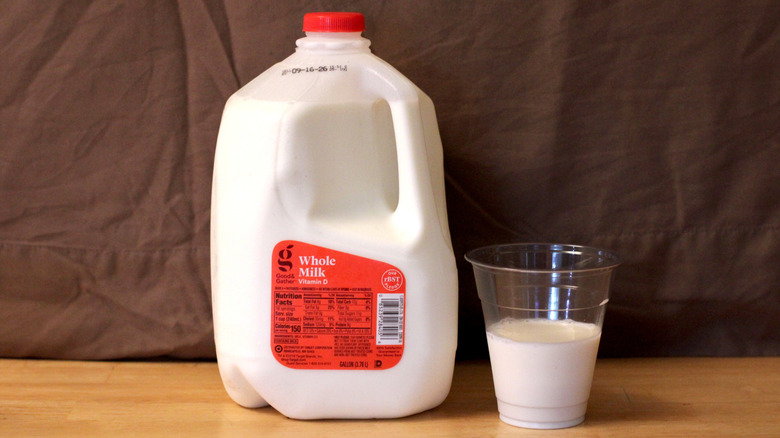 A jug of Good & Gather brand whole milk beside a cup of milk