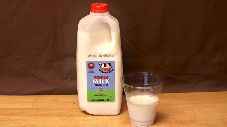 A jug of Rhody Fresh brand whole milk beside a cup of milk
