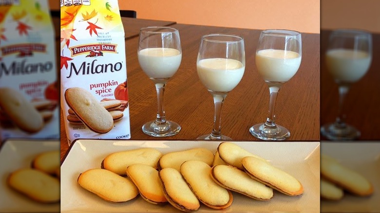 Milano pumpkin spice cookies on a rectangular plate and three glasses of milk behind them.