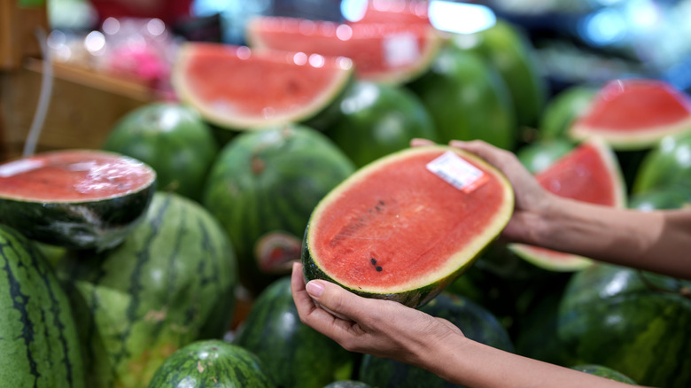 Whole and sliced watermelons at a market
