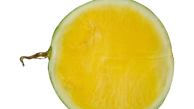Halved Tropical Sunshine watermelon on a white backdrop