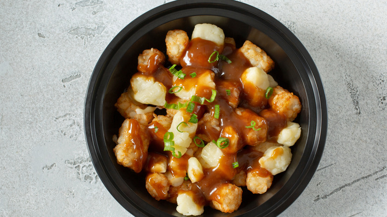 A black bowl of tater top poutine