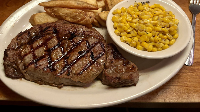 A steak, buttered corn, and fries from Texas Roadhouse