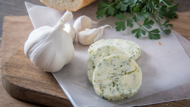 A garlic clove next to garlic butter