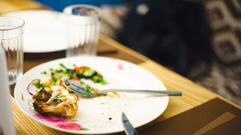 Mostly empty plate with leftover food with spoon