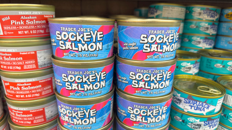 Canned salmon stacked on grocery store shelf