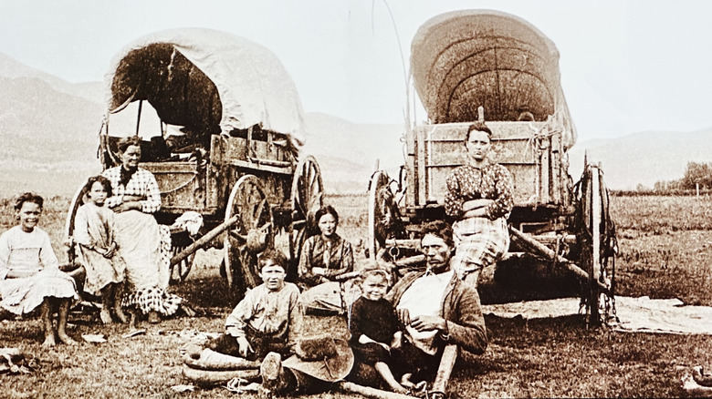 Old photo of  people with 19th century wagons