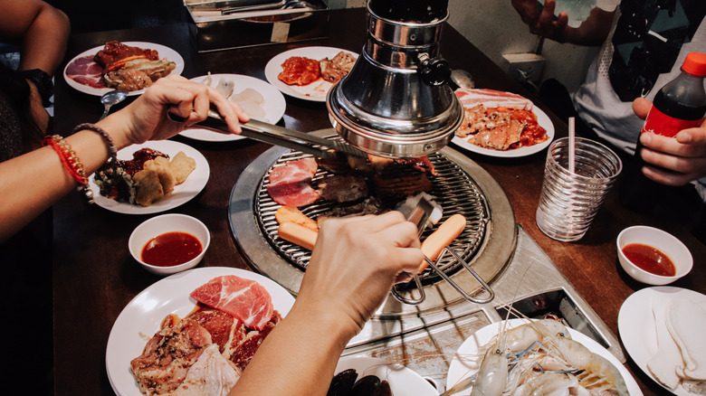 Diners cooking meat at a traditional Korean BBQ
