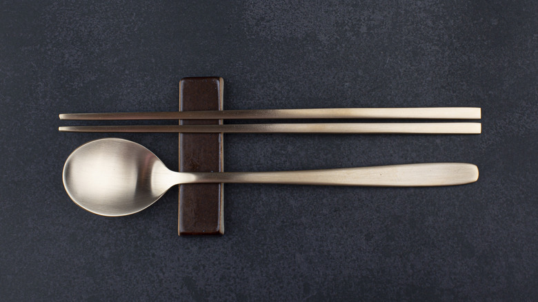 Korean metal spoon and chopsticks on a rest