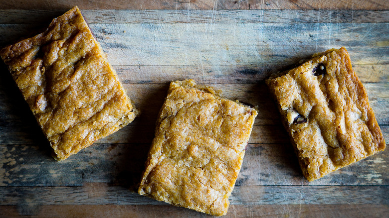 three cookie bars on a wooden surface