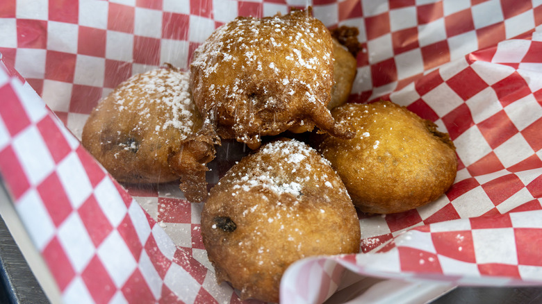 deep fried cookies with powered sugar in red and white checkered wrapper