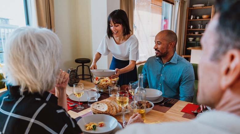 Smiling group of friends and family sharing pasta
