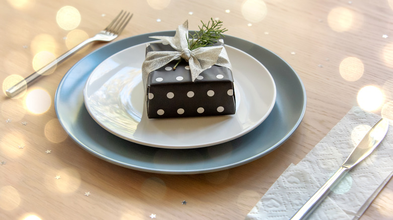 A simple place setting on a table topped with a wrapped gift